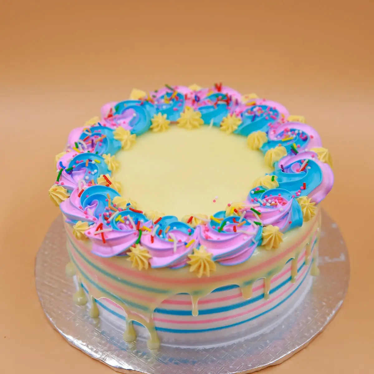 A cake piped with pink, blue and yellow flowers